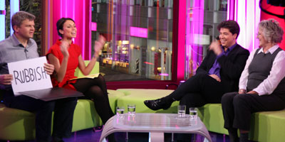 Adrian holding signs that say: Vote for Christine, even if she's rubbish!