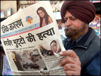 بے نظیر کے قتل کی خبر پڑھتا ایک شخص، فائل فوٹو