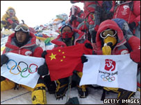 Alpinistas com a chama olímpica no topo do Everest