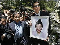 Tấm hình bà Nina Wang được con trai đỡ đầu của bà, Anthony Cheung, mang đi trong đám tang