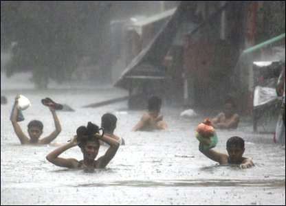 Người dân lội qua một con đường ngập nước do mưa lớn gây ra