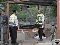 ماموران اسرائيلی جسد يک زن را که در اثر پرتاب راکت از سوی فلسطينی ها کشته شد حمل می کنند