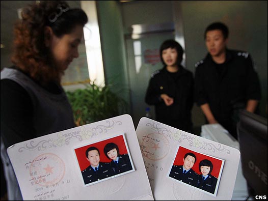 新疆乌鲁木齐市天山区民政局婚姻登记处一对警官恋人办理结婚证(中新社图片9/9/2009)