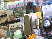 فروش دوربين نظامی، چراغ دستی (چراغ قوه) و دوربين سر تفنگ آمريکايی، در بازاری کارخانو پيشاور