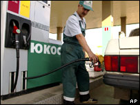 Yukos istasyonunda bir görevli otomobile benzin dolduruyor