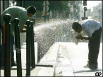 Franceses se refrescam em uma rua de Paris
