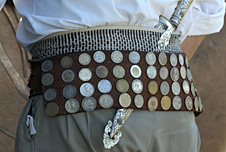 Argentinian cowboy wearing an ornamental belt adorned with coins and holding a knife