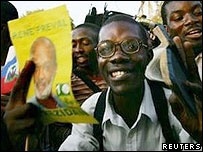 Simpatizante com santinho de René Préval em comício em Porto Príncipe