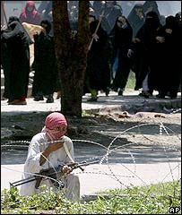 Homem armado e alunas em frente a mesquita em Islamabad