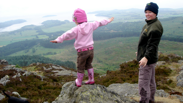young girl on top of mountain
