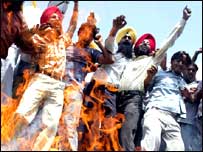 आयोग की रिपोर्ट की प्रति जलाते प्रदर्शनकारी