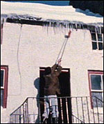 Man removing ice from house