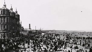 A large beach crowded with various people in Victorian dress.