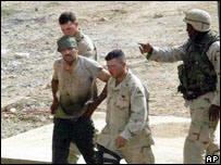 Soldados americanos conduzem rebelde ferido em combate