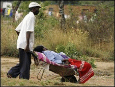Một người Zimbabwe đẩy người thân tới khám tại phòng khám dịch tả tại Harare (ngày 25 tháng 11 năm 2008)