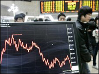 Học sinh Hàn Quốc đi qua một bảng chỉ số chứng khoán