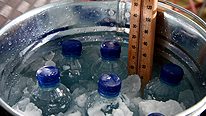 The mineral bottles are put into a bucket with ice, water and salt added.