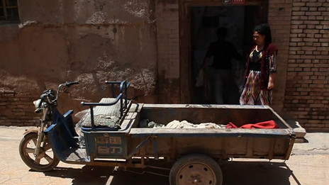 一辆农用三轮车停在喀什古城某民宅外