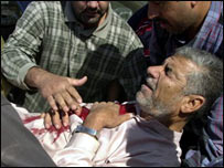 Iraquianos socorrem homem ferido durante tiroteio em posto de controle em Ramadi