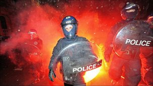 British riot police come under attack from flares as they clash with protestors during student demonstrations in Parliament Square, in London, on December 9, 2010