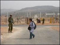 Menina passa pelo portão de Jebara observada por soldado (foto de Efrat Torjdman)