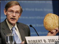 Zoellick segura pedaço de pão em coletiva