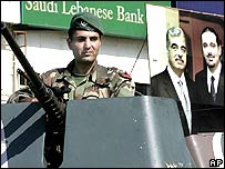 سرباز لبنانی در برابر پوستر رفيق حريری و پسرش