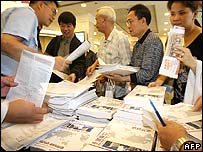 Broşürleri inceleyen yatırımcılar