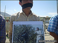 یک تظاهرکننده در کابل، عکسی از تیراندازی پلیس به تظاهرکنندگان شبرغان را در دست دارد