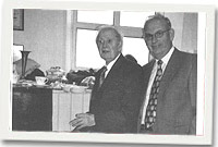 Mr Lindsay Williams y diacon hynaf yn torri'r gacen