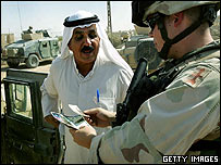 Soldado americano checa documentos de um iraquiano