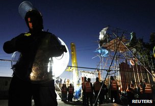 A police officer stands guard as bailiffs dismantle barricades at the Dale Farm Traveller site, October 2011