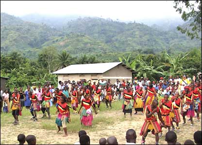 Lines of colourfully dressed dancers performing with the Ruwenzori mountains in the background.