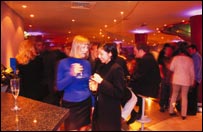 Mulheres e homens bebem em bar londrino