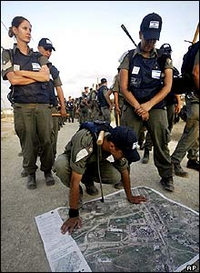 Izraelští policisté nad mapou Kfar Daromu