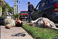A policeman stands between two dead men