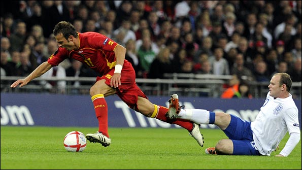 Wayne Rooney brings down Zverotic. Photo: AP