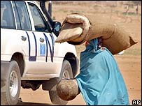 زنی مواد امدادی سازمان ملل را در اردوگاهی در دارفور حمل می کند