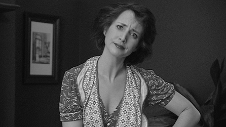 Black and white photograph of Lucy Owen dressed as a 1950s housewife.