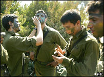 Soldados israelenses preparam camuflagem antes de cruzar a fronteira com o Líbano