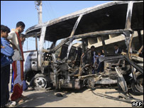 Iraquianos observam ônibus destruído pelo ataque em Shaab