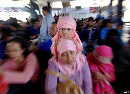People wait at a bus station in Denpasar, Bali,