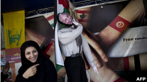 Mulher iraniana ao lado de imagem do primeiro-ministro israelense, Binyamin Netanyahu, em protesto contra Israel (Foto: AFP/Getty Images)