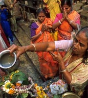 Indian women making offering to Shiva on the Ganges, Calcutta, India