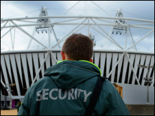A security guard stands out side the Olympic Stadium at Olympic Park in Stratford, London, England