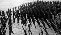 While en route to Africa to take part in Operation Torch (the Allied landings in Morocco), enlisted men do their jumping jacks on the flight deck of the aircraft carrier USS 'Santee'