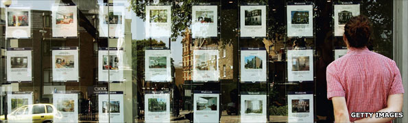 Man looking at window of an estate agents