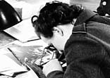 A WAAF section officer examines reconaissance photos