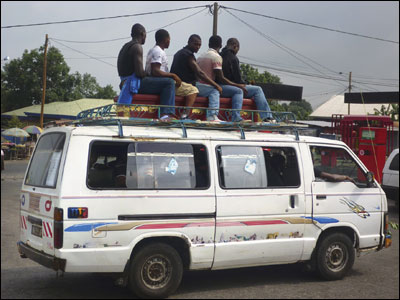 Five men hitch a ride on top of a coffin in the town of Buea