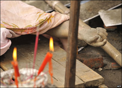 Nến thắp cạnh một thi thể ở Dujiangyan, Tứ Xuyên, 14/05